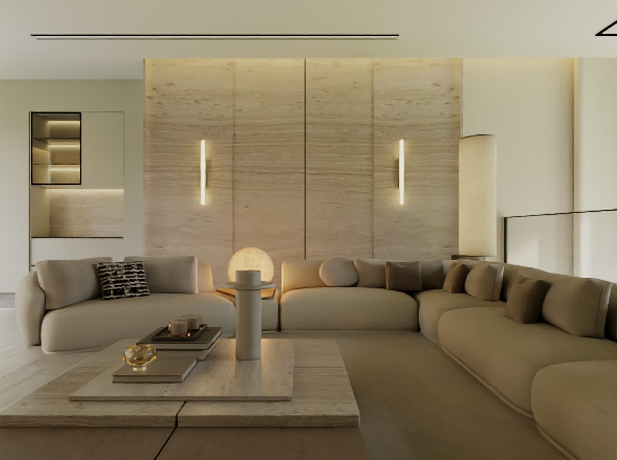 A sitting room with a travertine feature wall lit by two slim wall lights, a glowing globe lamp and deep sectional seating, designed by Radwa Interiors.