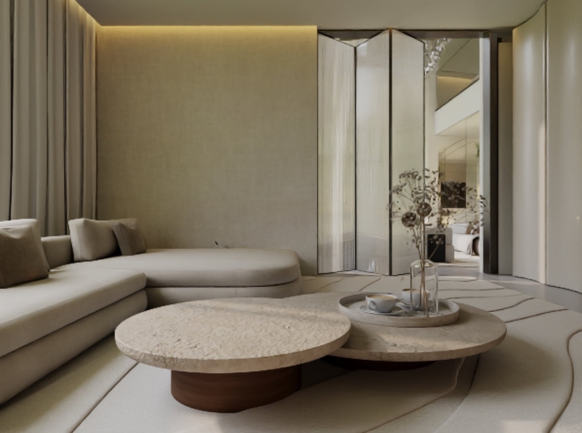 A sitting room with a low cream sectional and two round stone tables, beside a folded mirrored screen, designed by Radwa Interiors.