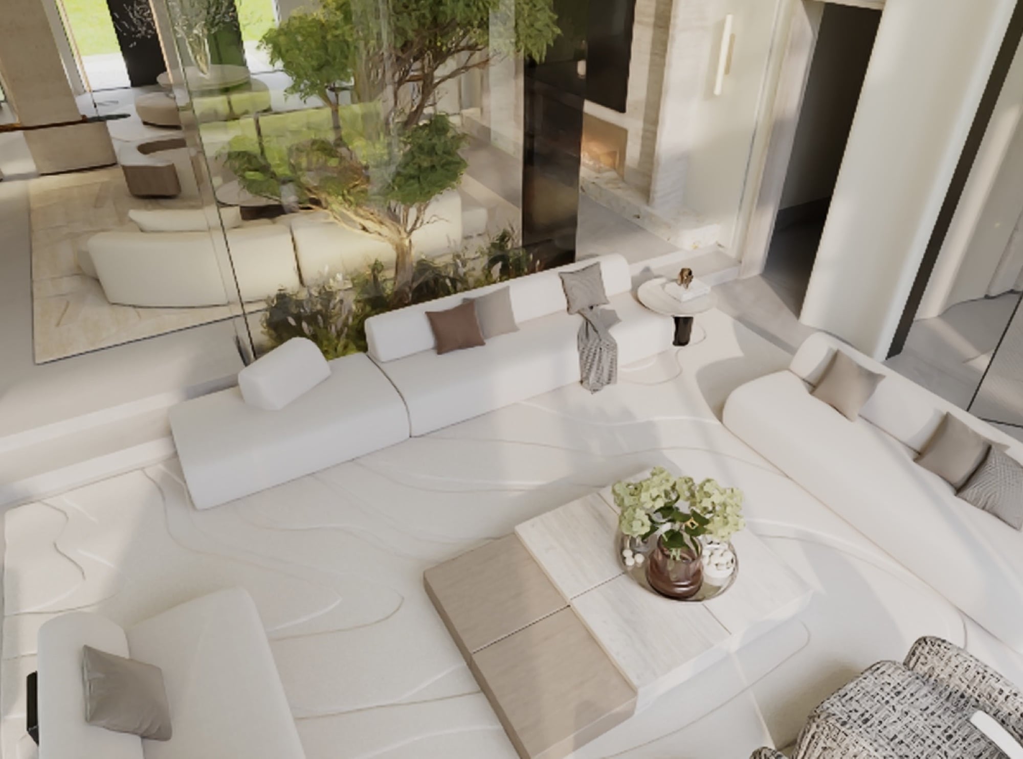 An overhead view of white sofas and a low stone table on a patterned floor, beside a courtyard tree behind glass, designed by Radwa Interiors.