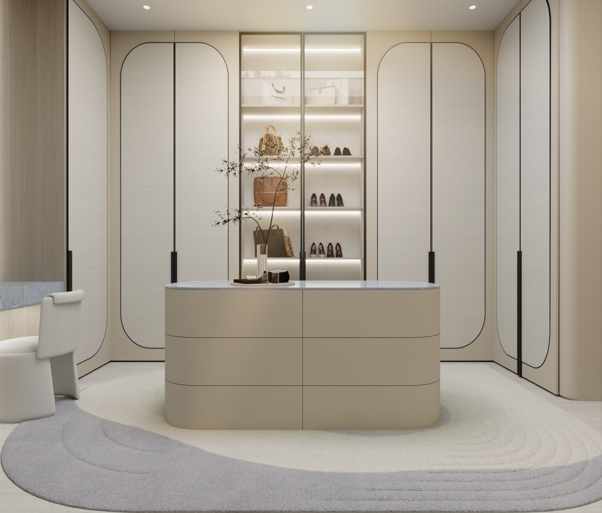 A dressing room of arched cream cabinetry around a curved island, with a lit display bay of bags and shoes, designed by Radwa Interiors.