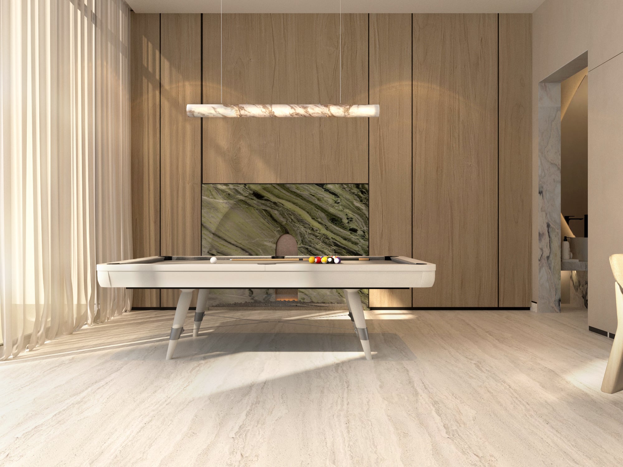 A games room with a pale pool table before a green marble panel, under a linear onyx pendant on timber panelling, designed by Radwa Interiors.