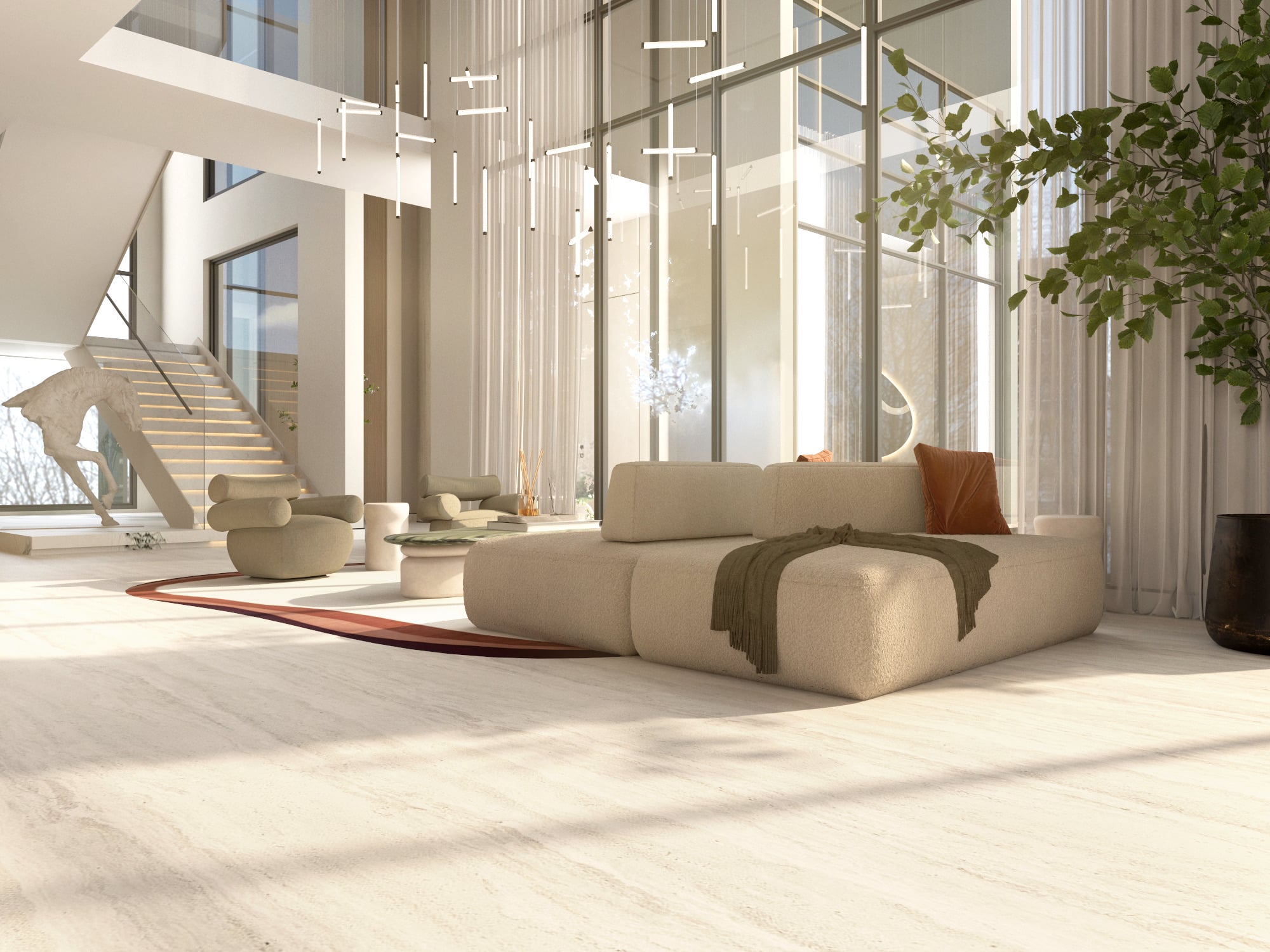 A double-height room with a low cream sofa on a rust-red rug, under a scatter of linear pendants beside a staircase, designed by Radwa Interiors.