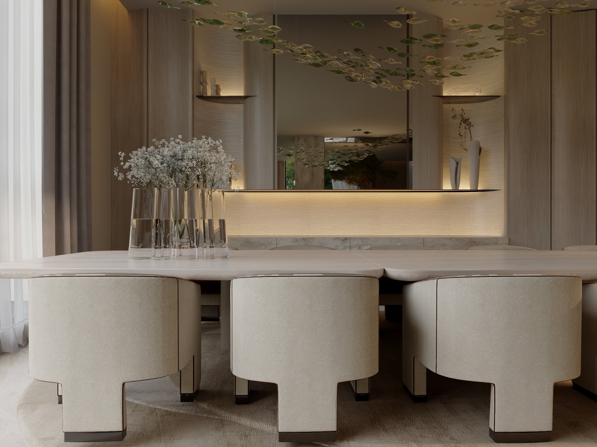 A dining table with cream sculpted chairs before a backlit stone counter and mirror, with gypsophila in glass vases, designed by Radwa Interiors.