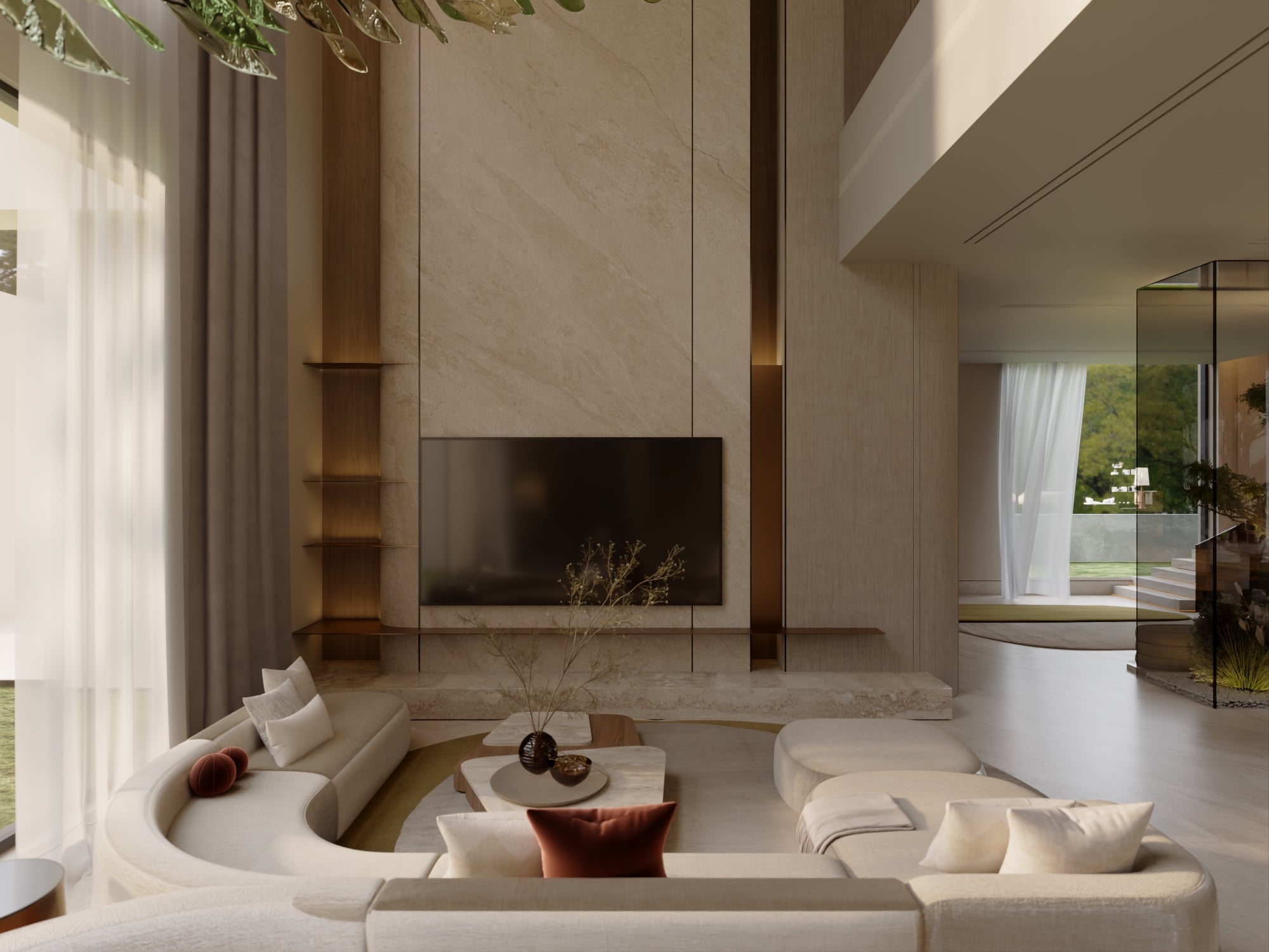A double-height living room with a screen set into a travertine chimney breast, curved cream seating and a rust cushion, designed by Radwa Interiors.