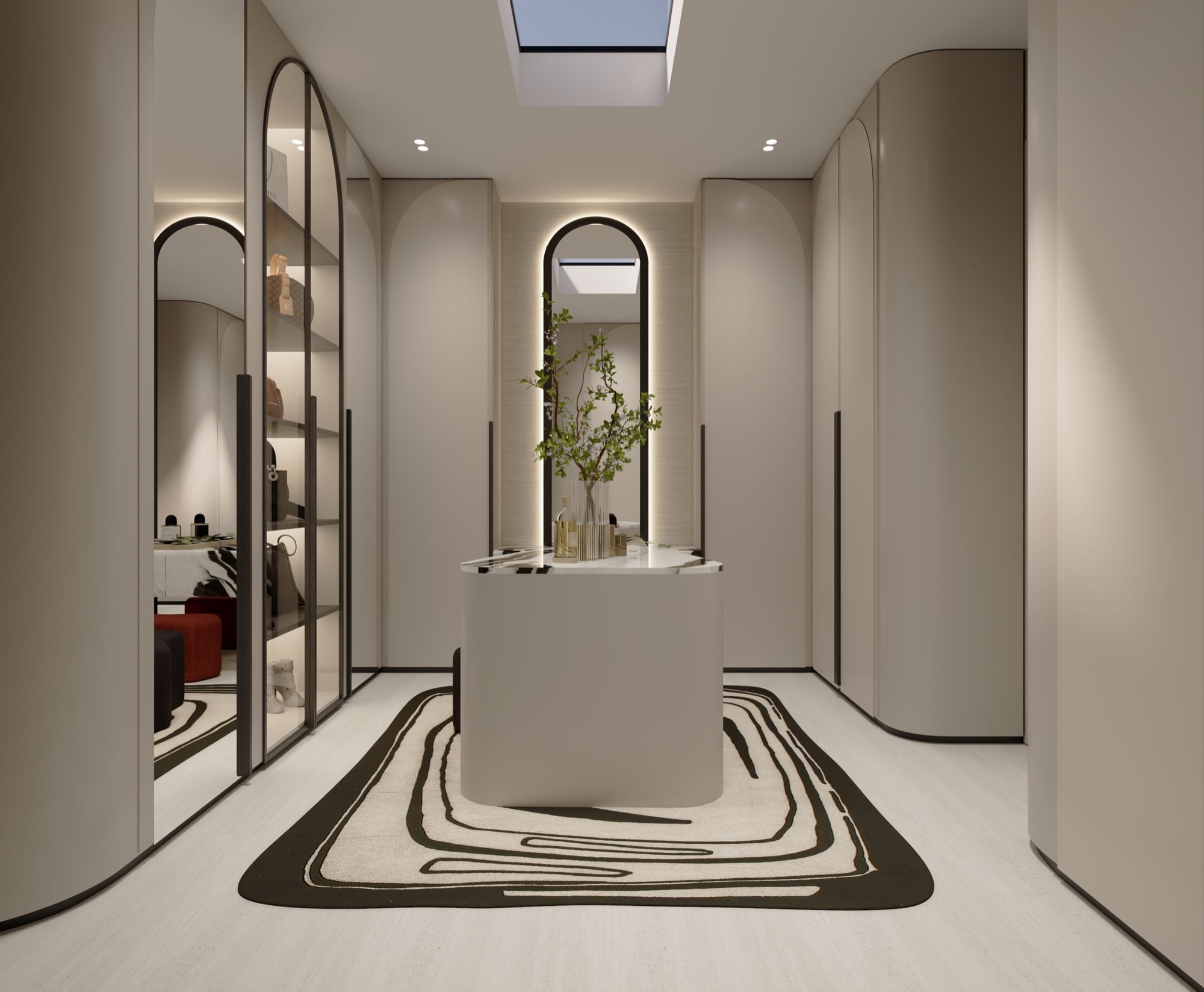 A dressing room lined with arched cream cabinetry around a curved island, lit by a skylight above a black and white line-drawn rug, designed by Radwa Interiors.