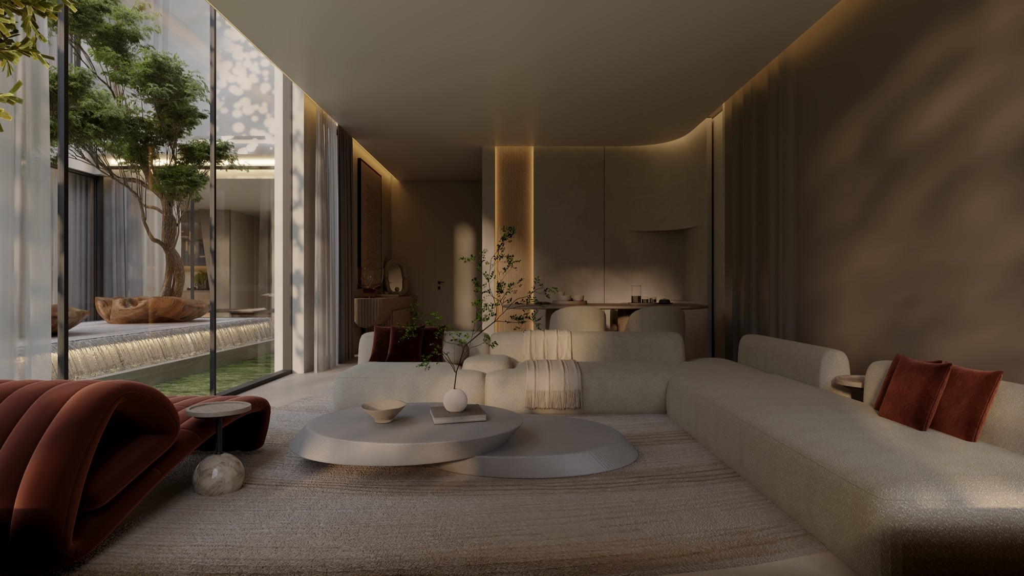 An evening living room with a rust chaise and cream sectional, beside a lit courtyard tree behind glass, designed by Radwa Interiors.