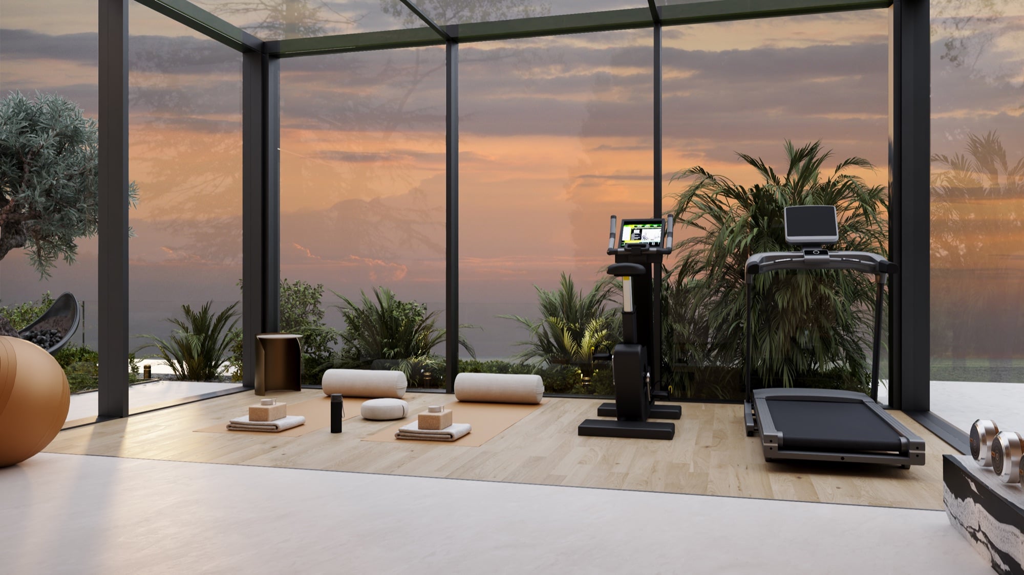 A gym looking out through full-height glazing to a sunset sky, with a yoga mat, rollers and an exercise ball, designed by Radwa Interiors.