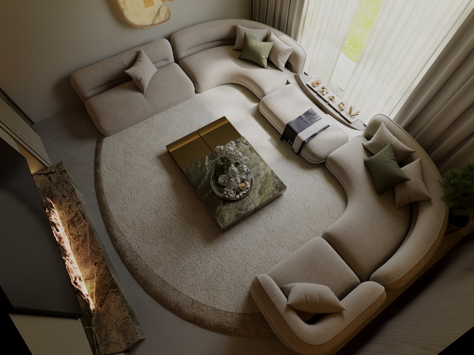 An overhead view of a curved cream sectional around a green marble table on a circular rug, beside a linear stone fireplace, designed by Radwa Interiors.
