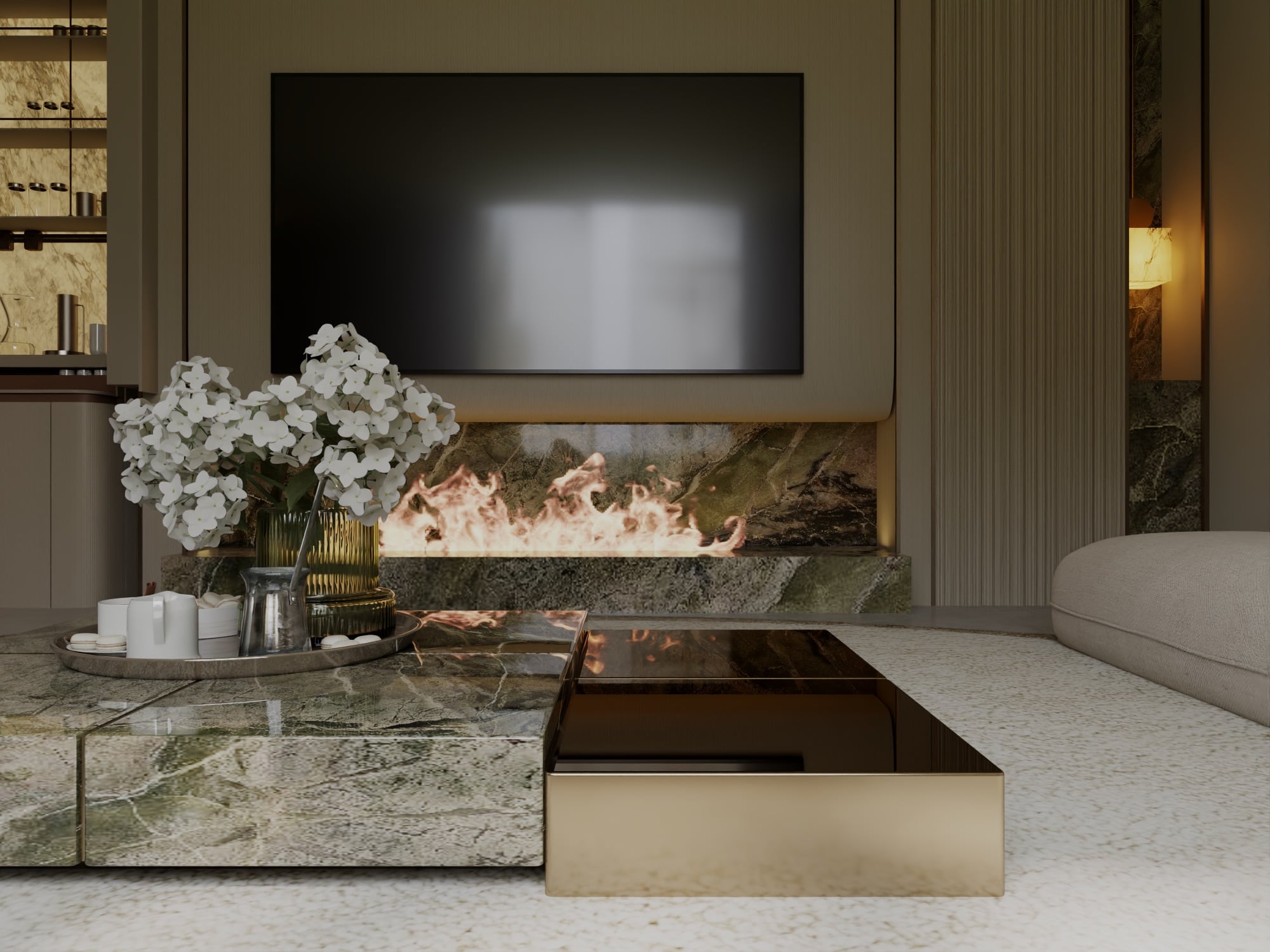 A living room fireplace set into a veined stone hearth below a wall-mounted screen, with a bronze-topped table in the foreground, designed by Radwa Interiors.