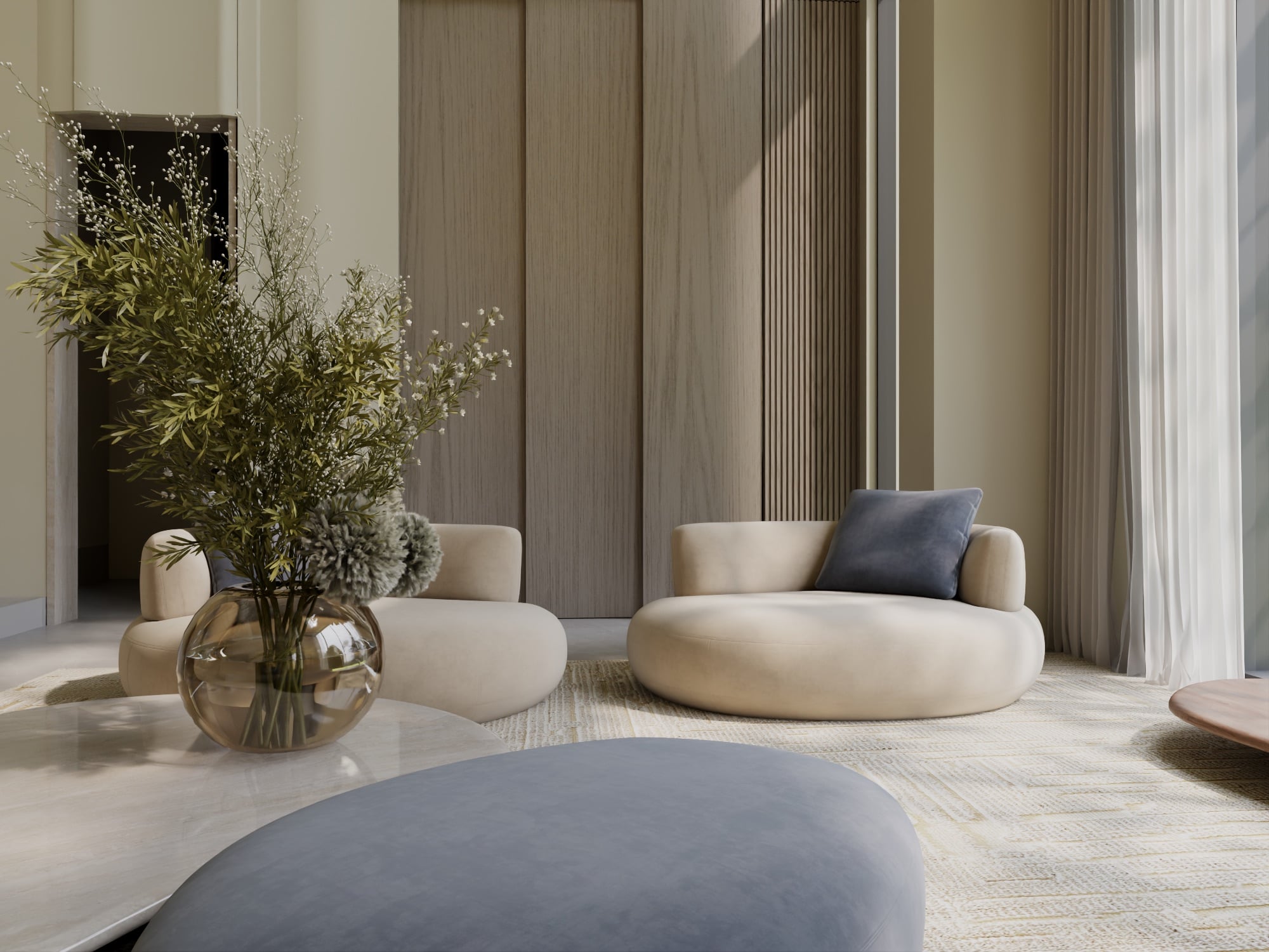 A seating group with a bronze glass vase of olive branches, against fluted timber panelling and sheer curtains, designed by Radwa Interiors.